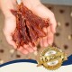 Hände halten Streifen von getrocknetem Fleisch mit einem Abzeichen, das besagt: "Bewährte Qualität seit über 15 Jahren - Best Quality."