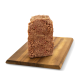 Eine Scheibe Haustierfutterlaib, die auf einem Holzschneidebrett präsentiert wird, mit ihrer strukturierten Oberfläche und fleischiger Farbe.