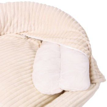 Ein plüschiges, cremefarbenes Haustierbett mit einem gerippten äußeren Rand und einem Reißverschluss, der weiche, weiße Innensofas offenbart.