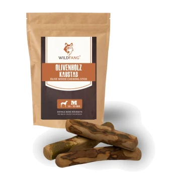 Braune Verpackung mit der Aufschrift "WILDFANG OLIVENHOLZ KAUSTAB OLIVE WOOD CHEWING STICK" mit einer Größenangabe "L 25-45 KG" und drei Olivenholz-Stäben.