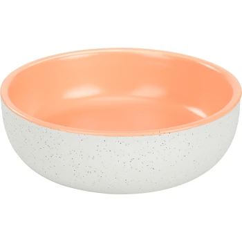 A round pet food bowl with a speckled white exterior and a smooth peach interior.