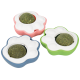 Three paw-shaped pet toys in pink, blue, and green with white tops and green herb balls in the center.