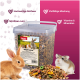 Ein klarer Behälter mit PANTO Nagerfutter mit Samen und Pellets, beschriftet für Vitamine und Ballaststoffe, neben einem braunen Kaninchen und einem Hamster.