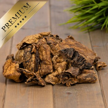 Getrocknete Hundeleckerlis auf einer Holzoberfläche angeordnet, mit einem goldenen "PREMIUM"-Abzeichen in der Ecke, das hohe Qualität anzeigt.