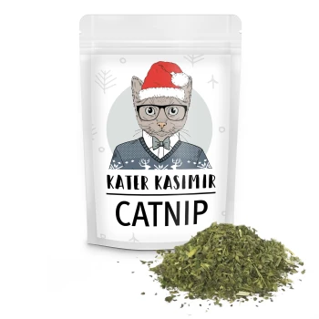 Eine Packung Katzenminze mit der Aufschrift "Kater Kasimir" und einer Cartoon-Katze mit einem Weihnachtsmannhut, neben einem Haufen getrockneter Katzenminze.