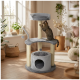 Arbre à chat gris à plusieurs niveaux avec poteaux à griffer et jouets suspendus dans un salon ensoleillé, un chat tigré gratte le deuxième niveau