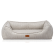 Ein plüschiges, beiges Hundebett mit vertikal geripptem Stoff und einem weichen, gepolsterten Innenraum, mit einem kleinen braunen Etikett mit "KNUFFELWUFF."