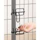 Eine Hand öffnet einen schwarzen Metallriegel an einem grauen Haustiergehege-Tor, das das Drahtgitterdesign des Tores zeigt.