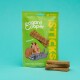 Emballage de friandises pour chiens Edgard Cooper vert étiqueté "STICKS", présentant un chien et un chat de dessin animé avec "Miaaaam" et "Agneau frais, oui vraiment."