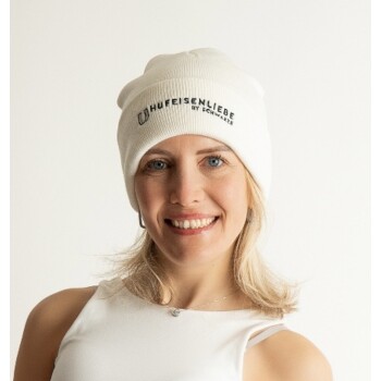 Eine Person, die eine weiße Mütze mit dem Text "LIFE IS ENLIFE" und ein weißes Tanktop trägt, posiert vor einem schlichten Hintergrund.