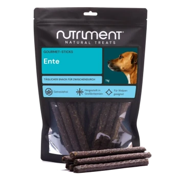 Nutriment Natural Treats Gourmet-Sticks ‚Ente‘ 1 kg Tüte mit dunklen Enten-Kaustangen für Hunde, einige davon vorne gestapelt.