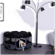 Ein kleiner weißer Welpe mit braunen Flecken verlässt einen schwarzen und grauen Laufstall, hält ein blaues Spielzeug, mit einer Lampe und einem Sofa im Hintergrund.