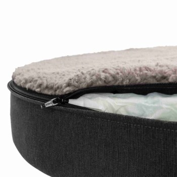 Nahaufnahme eines Haustierbettes mit einer plüschigen, abnehmbaren Oberseite in Hellgrau und einem dunkelgrauen Reißverschlussboden, der das zweilagige Design zeigt.