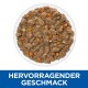Eine Schüssel mit feuchtem Haustierfutter, die Stücke von Fleisch und gewürfeltem Gemüse enthält, mit dem Text "HERVORRAGENDER GESCHMACK" darunter.