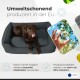 Ein brauner Hund sitzt auf einem grauen Haustierbett und leckt sich die Lippen. Der Text lautet "Umweltschonend produziert in der EU" mit Recycling-Symbolen.