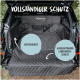 Schwarze, gesteppte Autositzabdeckung für Haustiere in einem SUV, beschriftet mit "VOLLSTÄNDIGER SCHUTZ," mit Hervorhebung von "SEITENSCHUTZ" und "AUSKLAPPBARER LADEKANTENSCHUTZ."
