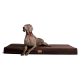 Ein grauer Weimaraner-Hund mit rotem Halsband liegt auf einem großen, dunkelbraunen Haustierbett und schaut aufmerksam zur Seite.