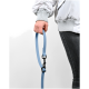 Eine Person hält eine hellblaue Hundeleine mit einem schwarzen Clip, trägt eine weiße Jacke und graue Jeans, vor einem schlichten weißen Hintergrund.