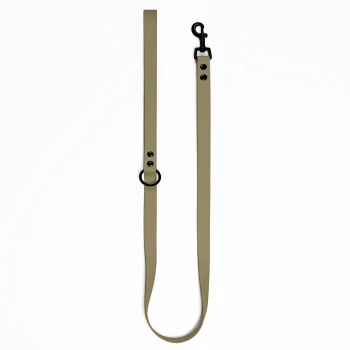 Eine lange, olivgrüne Hundeleine mit einem schwarzen Metallclip und zwei schwarzen Druckknöpfen zur Anpassung, vor einem weißen Hintergrund präsentiert.