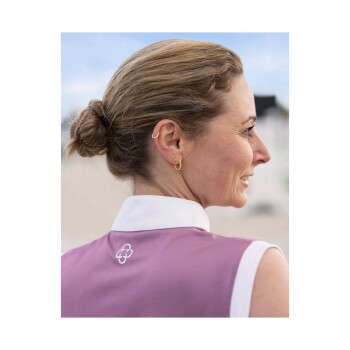 Eine Frau mit einem Dutt trägt ein lila Hemd mit einem weißen Kragen, mit einem Logo auf dem Rücken.