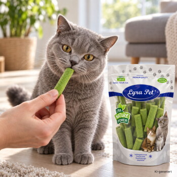 Getigerte Katze schnüffelt an einem grünen Snack-Stick, der von einer Hand gehalten wird; ein Treat-Beutel von Lyra Pet mit der Aufschrift „Nature Power“ ist sichtbar