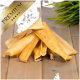 Ein Stapel hochwertiger Hundekauartikel auf einer Holzoberfläche, mit einer grünen Pflanze im Hintergrund und einem goldenen 'PREMIUM'-Banner in der Ecke.