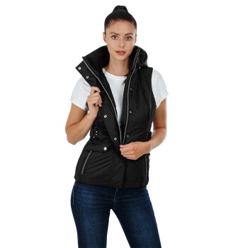 Eine Frau trägt eine stylische schwarze Daunenweste über einem weißen T-Shirt, kombiniert mit blauen Jeans, und posiert mit ihren Händen auf der Weste.