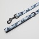 Eine blau-weiße Hundeleine mit Batikmuster, mit einem schwarzen Metallclip und einer Schlaufe zum Halten.