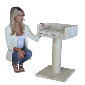 Eine Frau in einem weißen Blazer kniet neben einem plüschigen beigen Katzenbaum mit einer weichen, gepolsterten Plattform und einem stabilen Kratzbaum.