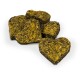 Heart-shaped herbal pet treats made from dried herbs and flowers, arranged on a white background.