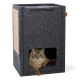 Eine flauschige Katze liegt in einem dunkelgrauen Filz-Katzenhaus mit einer Kratzfläche an der Seite, das einen quadratischen Eingang hat.