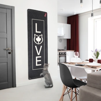 Kratzteppich 180x60cm mit Wandbefestigung anthrazit Eine graue Katze steht auf ihren Hinterbeinen neben einer schwarzen Matte mit "LOVE" und einer Katzensilhouette in einer modernen Küche.