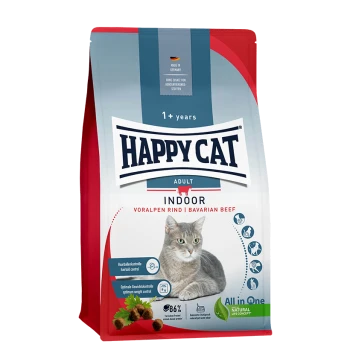 Happy Cat Adult Indoor Katzenfuttertüte mit einer grauen Katze, gekennzeichnet als "Voralpen Rind | Bayerisches Rindfleisch," mit Text zu Haarballen und Gewichtskontrolle.