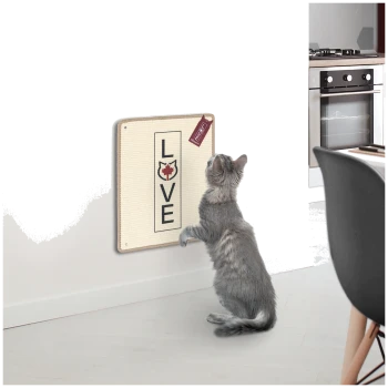 Eine graue Katze steht auf den Hinterbeinen und greift nach einem wandmontierten Kratzbrett, das in fetten Buchstaben "LIEBE" sagt.