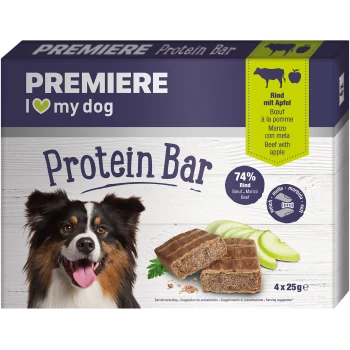 Proteinriegel 4x25 g Rind mit Apfel Eine Verpackung des PREMIERE Protein Riegels für Hunde mit einem glücklichen Australian Shepherd. Der Riegel enthält 74% Rindfleisch und Apfel, mit vier 25g Riegeln sichtbar.