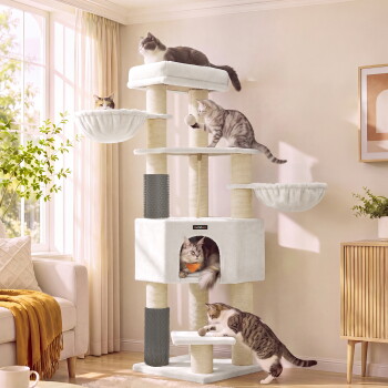 Weißer mehrstöckiger Kratzbaum in einem sonnenbeschienenen Wohnzimmer mit fünf Katzen auf Plattformen, Hängematten und Katzenhöhle; kleines Markenetikett sichtbar.