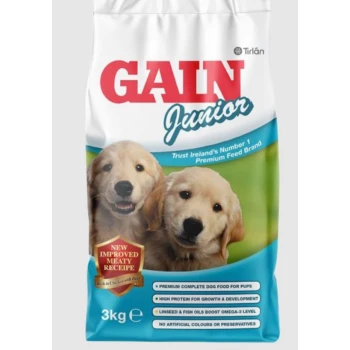 Gain Junior dog food bag featuring two golden retriever puppies, with text highlighting "NEW IMPROVED MEATY RECIPE" and nutritional benefits.