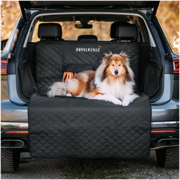 Ein Hund, der auf einem schwarzen gesteppte Haustier-Sitzbezug im Kofferraum eines SUVs ruht, mit dem sichtbaren Text "Rudel König" auf dem Bezug.