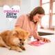 Een fluffy Pomeriaan kauwt op een stok, terwijl een persoon traktaties voorbereidt in een roze mal. 'ORIGINAL CHEW STICKS' staat in een hartvorm erboven.