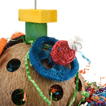 Buntes Vogelspeilzeug aus natürlichen Materialien, mit einer Basis aus Kokosnussschale, lebhaften gewebten Texturen und verspielten hängenden Elementen.