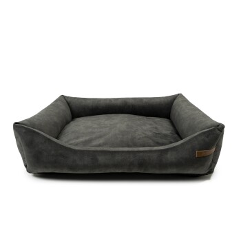 Graues Haustierbett mit erhöhten Kanten und einem weichen, plüschigen Innenraum, mit einem kleinen Lederetikett an der Seite.