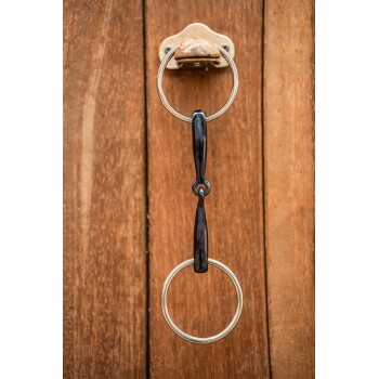 Eine Nahaufnahme eines Haustierleinenhakens aus Metall, mit zwei runden Ringen und einem schwarzen Griff, montiert an einer Holzwand.