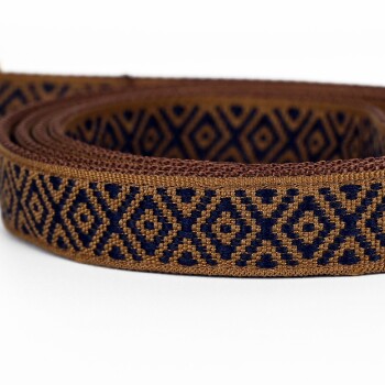 Eine Nahaufnahme einer dekorativen Haustierleine mit einem braunen und marineblauen geometrischen Muster, ordentlich auf einem weißen Hintergrund gewickelt.