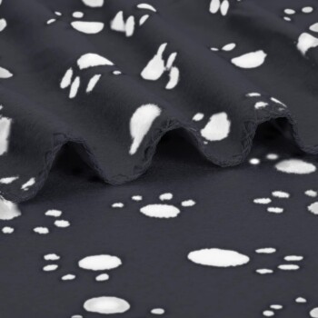 Schwarze Fleece-Tierdecke mit weißem Pfotenmuster, gefaltet, um die weiche Textur und die abgesteppten Kanten zu zeigen.