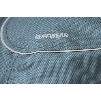 Nahaufnahme eines blauen Tieraccessoires mit dem weißen 'RUFFWEAR'-Logo, das strukturierten Stoff und eine gepaspelte Kante zeigt.