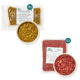 Tierfutterprodukte: sechs Gemüsemischpakete, eine Schüssel mit Mischfutter und ein Paket rohes Fleisch, alle mit Nährwertangaben.