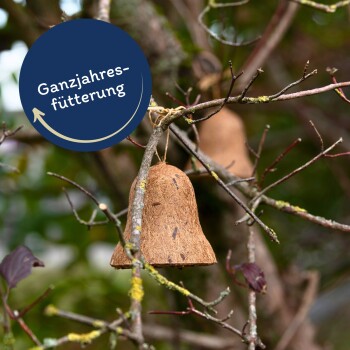 Ein natürlicher Vogelfutterspender in Form einer Glocke, der von einem Baumzweig hängt, mit dem Text 'Ganzjahresfütterung' in einem blauen Kreis.