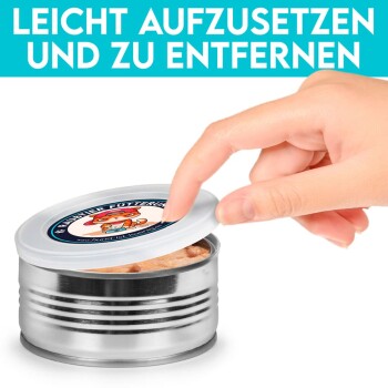 Eine Hand hebt den Deckel einer Metall-Dosenfutterdose für Haustiere an und zeigt weiches Futter darin. Der Text darüber lautet 'LEICHT AUFZUSETZEN UND ZU ENTFERNEN.'