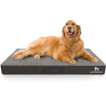 Ein Golden Retriever liegt bequem auf einem grauen Haustierbett mit strukturierter Oberfläche, mit dem Markennamen "KNUFFELWUFF" an der Seite.