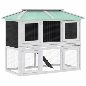 Ein zweistöckiges Haustierhaus mit einem grünen schrägen Dach, grauen Holzpaneelen und Maschendrahttüren, entworfen für kleine Tiere.